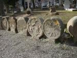 Esteles funeràries i lloses sepulcrals<br>Sanaüja. Cementiri: Fragment de la sèrie de les gairebé 70 esteles funeràries visibles al cementiri de Sanaüja. Tot i estar en una fase de degradació galopant, a l'estar exposades a l'intempèrie, encara predomina la seva més o menys fàcil identificació. En la que veiem en primer terme podem observar una roda solar. El conjunt d'esteles és datable en el periode comprés des del s. XIII al XIX, amb una abundant representació de les èpoques medievals. Autor: Jordi Bibià Esteles funeràries i lloses sepulcrals<br>Sanaüja. Cementiri: Fragment de la sèrie de les gairebé 70 esteles funeràries visibles al cementiri de Sanaüja. Tot i estar en una fase de degradació galopant, a l'estar exposades a l'intempèrie, encara predomina la seva més o menys fàcil identificació. En la que veiem en primer terme podem observar una roda solar. El conjunt d'esteles és datable en el periode comprés des del s. XIII al XIX, amb una abundant representació de les èpoques medievals. Autor: Jordi Bibià