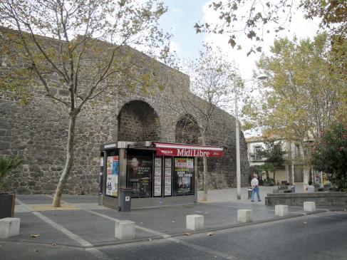 6.10.2009 Muralles a l'entrada d'Agde. A l'entrada de la plaça de la Belle Agathoise. Aquestes muralles són d'origen medieval, i foren bastides al s. XII per ordre del bisbe Guillem que volgué emmurallar la ciutat, seguint l'antic traçat que ja van iniciar els grecs. Es tractava doncs d'una vila closa amb els seus portals d'accés.                     Les remparts -  Jordi Bibià