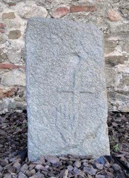 11.9.2010 Suposada llosa sepulcral localitzada a prop dels mus de l'església de Sant Joan (ss. XI-XII). Podem observar, tot i que lleugerament desplaçats, una creu i una mà. Treball d'escultura realitzat sobre roca granítica.            Palau Saverdera  -  Jordi Bibià