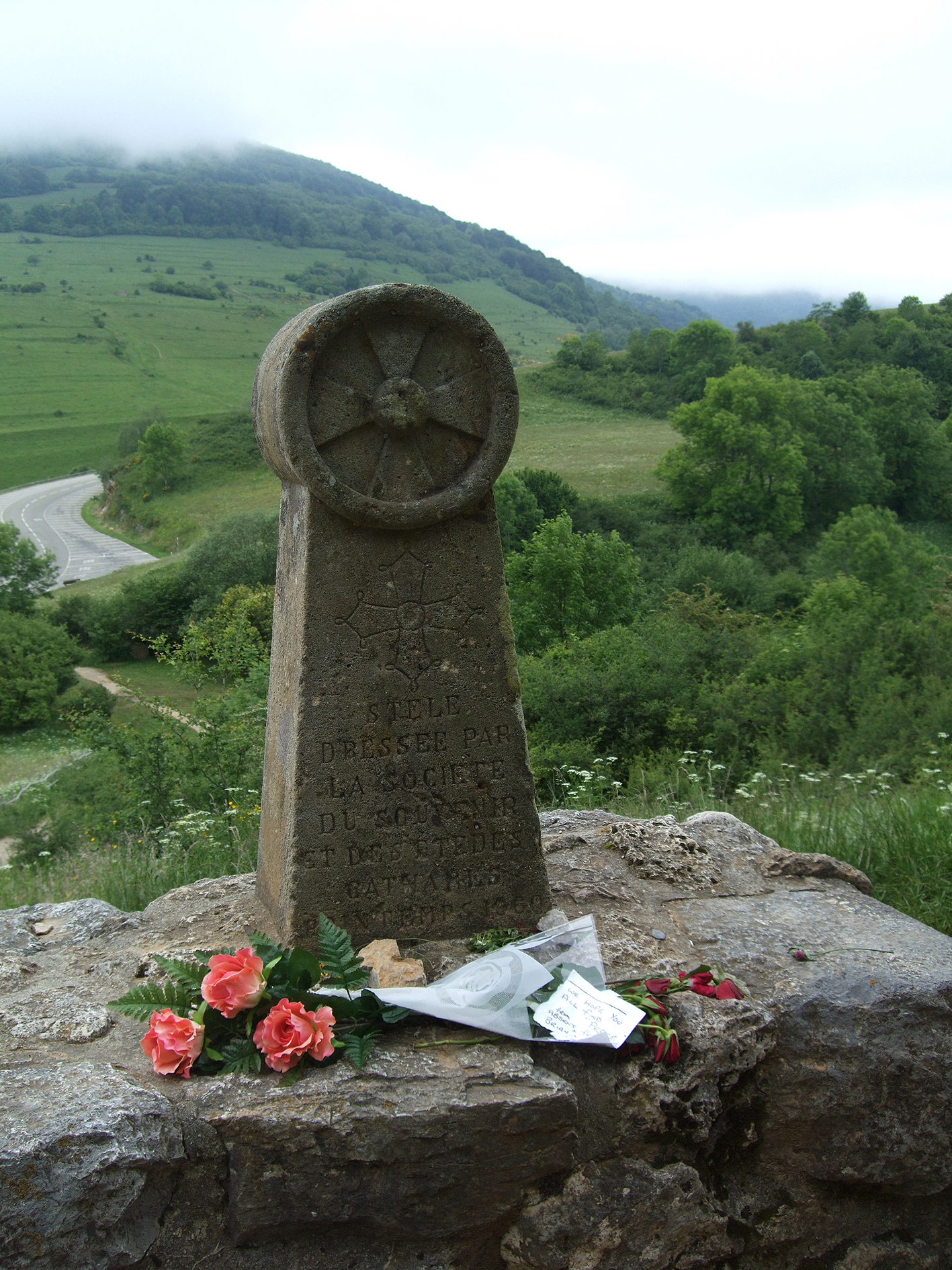 26.03.2008 Encara hi deixen flors. Estela/monument al Prat dels Cremats, aixecada als anys seixanta per la Sociéte du Souvenir et des Études Cathares. Dedicat a: «als màrtirs del més pur amor cristià».  Montsegur -  Jordi Bibià